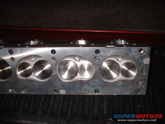 Aluminum engine cylinder head with visible valves and bolt holes