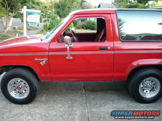 Red 1985 Ford Bronco II side view with 'Bronco II' badge visible