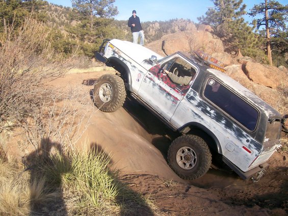 White 1978 Ford Bronco off-roading on a dirt hill