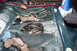 1994 Mazda 626 - The interior floor of a car is exposed, revealing the fuel pump assembly and wiring beneath the carpet.