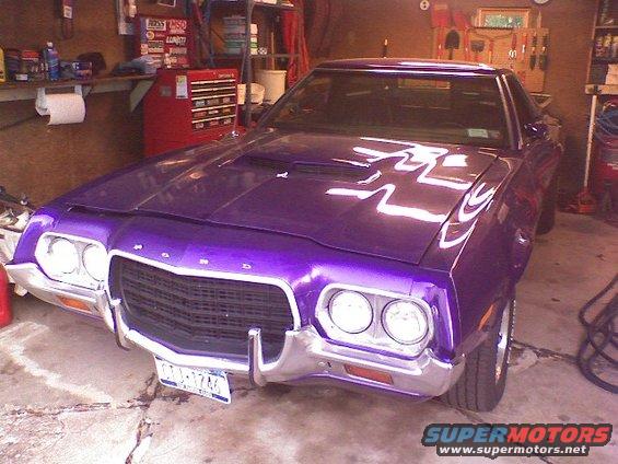 Purple Ford Ranchero parked in a garage. The grille and headlights are visible
