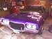 1974 Ford Ranchero - A purple Ford Ranchero is parked in a garage, showing its front grille and headlights.