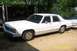 1991 Ford Crown Victoria LTD - This white 1991 Ford Crown Victoria LTD sedan is parked outdoors next to another white vehicle.
