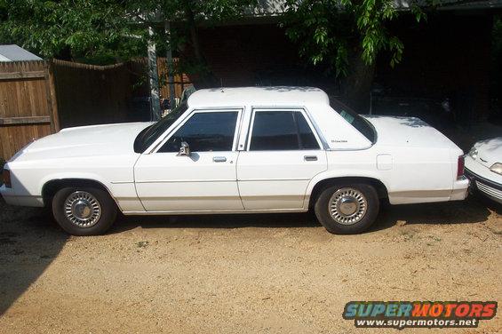 1991 Ford Crown Victoria LTD sedan, side view. Another car is partially visible on the right
