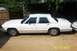 1991 Ford Crown Victoria LTD - Side profile of a white 1991 Ford Crown Victoria LTD parked outdoors next to another vehicle.