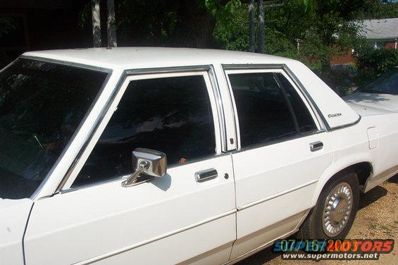 Side view of a white sedan with tinted windows and chrome trim