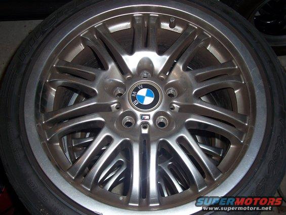 Silver BMW M wheel with a tire. Visible BMW logo and M badge