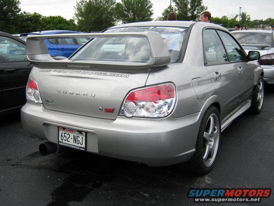 Silver Subaru WRX STI sedan, rear view, large spoiler, custom wheels