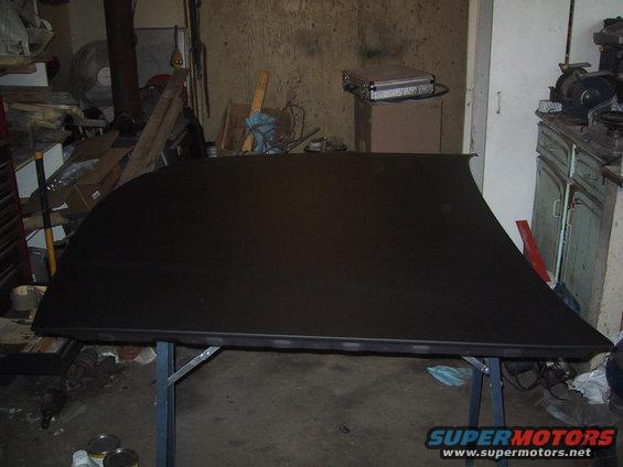 black car roof panel on a table in a garage