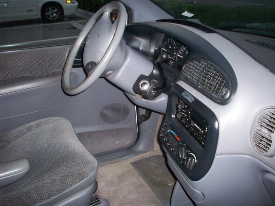 Interior of a minivan showing the steering wheel, dashboard, radio, and driver's seat