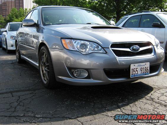 Silver Subaru Legacy sedan, front 3/4 view. License plate D55 9186