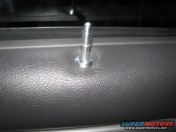 Door lock pin on textured gray interior panel