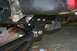 1989 Ford Bronco - Aftermarket suspension part installation on a vehicle frame, showing bolted connections and exhaust pipe.