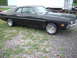 1970 Ford Falcon - A black 1970 Ford Falcon coupe is viewed from the front three-quarter angle, parked outdoors on a gravel lot.