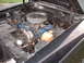 1970 Ford Falcon - The engine bay of a black vehicle, a blue Ford engine and a chrome air cleaner assembly.