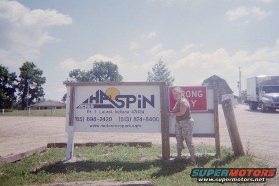 Signage for Haspin Acres with a person standing next to it, and a truck in the background