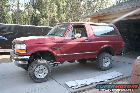 Red Ford Bronco with lifted suspension