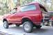 1989 Ford Bronco - Rear view of a red 1989 Ford Bronco with a lifted suspension and custom bumper.
