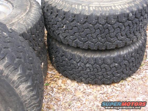 stack of used off-road tires on the ground