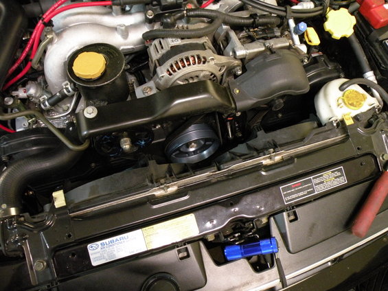 Engine bay of a 1998 Subaru Legacy, showing the alternator, belts, and pulleys