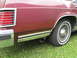 1984 Mercury Grand Marquis - The rear side of a maroon 1984 Mercury Grand Marquis is shown, with a focus on the wheel and chrome accents.