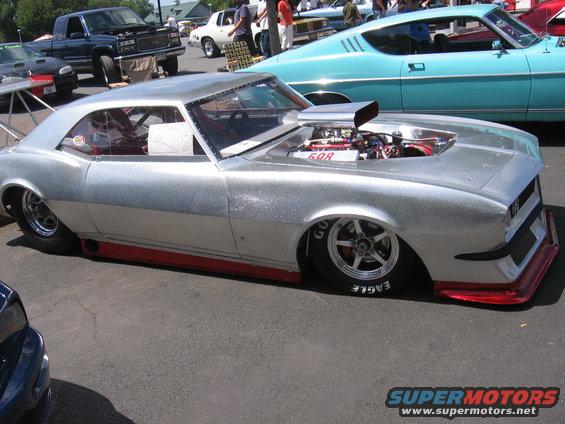 Silver customized classic car with exposed engine and red trim