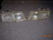 1995 Ford Taurus - A pair of headlights are shown, likely for a car, resting on a garage floor.