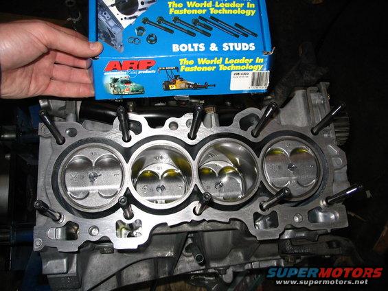 Engine block with pistons and ARP bolts box. Close-up view