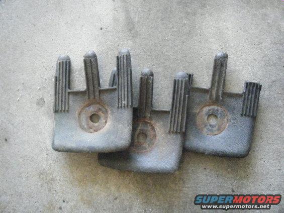 Three gray plastic car parts with ribbed posts and central circular indentations