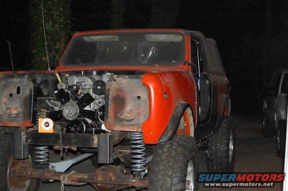 Orange SUV with front end removed, engine exposed, 3/4 front view