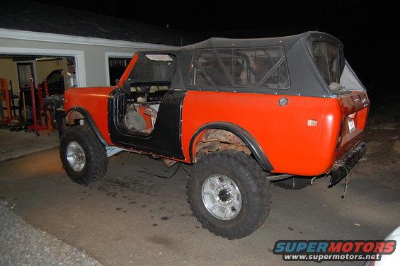 Orange International Scout II with black soft top and doors removed, parked in a driveway