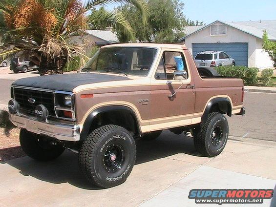 Brown and tan Ford Bronco with aftermarket wheels and tires, parked on a driveway