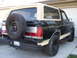1989 Ford Bronco - This 1989 Ford Bronco features a two-tone paint scheme with a black body and tan top, complemented by a rear-mounted spare tire.