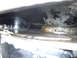 1989 Ford Bronco - Close-up view of a greasy underside of a vehicle component, showing oil residue and some metal parts.