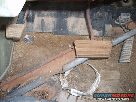 Car interior floor with rusty metal trim, pedals, and a 'PARK' label