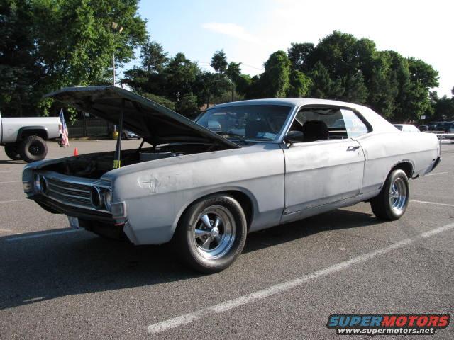 1969 Ford Torino primer gray coupe with hood open, parked in lot