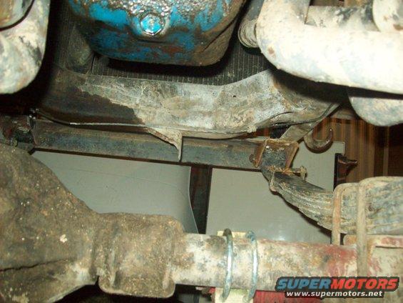 Underside view of a vehicle's drivetrain and suspension components, with some fluid leaks visible
