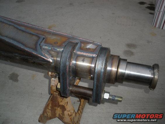 Custom welded rear axle assembly on jack stands, showing metal fabrication and a stamped number 4