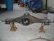 1995 Ford Bronco - A rear axle assembly is shown supported by two jack stands on a concrete floor.