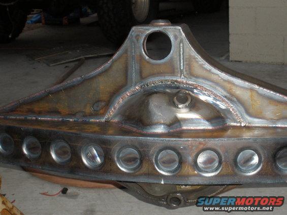 Custom rear axle housing with circular cutouts and visible welds
