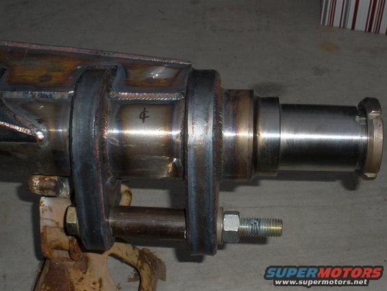 Close-up of a fabricated rear axle assembly supported by a jack stand