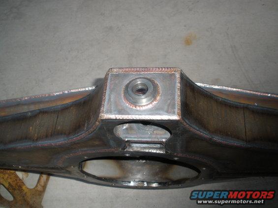 Close-up of a fabricated rear axle housing with visible welds and a central mounting point