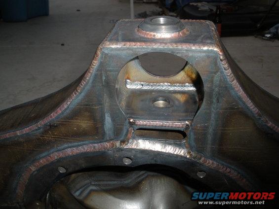 Welded steel rear axle housing with circular cutouts and mounting holes