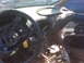 1995 Ford Bronco - The interior of a damaged vehicle shows a broken dashboard and steering wheel, with another car in the background.