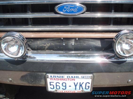 Front of a Ford truck with a blue Ford oval badge on the grille, two round auxiliary lights, and a Washington license plate