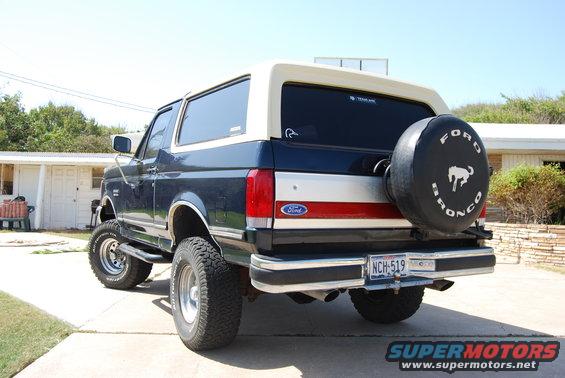 1991 Ford Bronco rear view, dark blue with tan top, spare tire on back