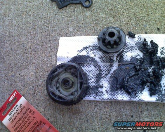 Window regulator gear parts and black grease on a paper towel, next to a HELP! brand package for window regulator gear plugs