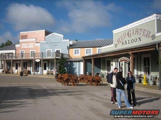 Western-themed buildings with 'Red Garter Saloon' sign, people standing in front