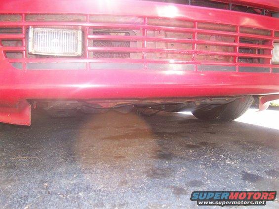 Red car front bumper and grille with visible headlight