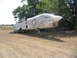 1981 Kawasaki Bayou - A weathered military jet aircraft with US Navy insignia is parked outdoors in a dry, grassy field.
